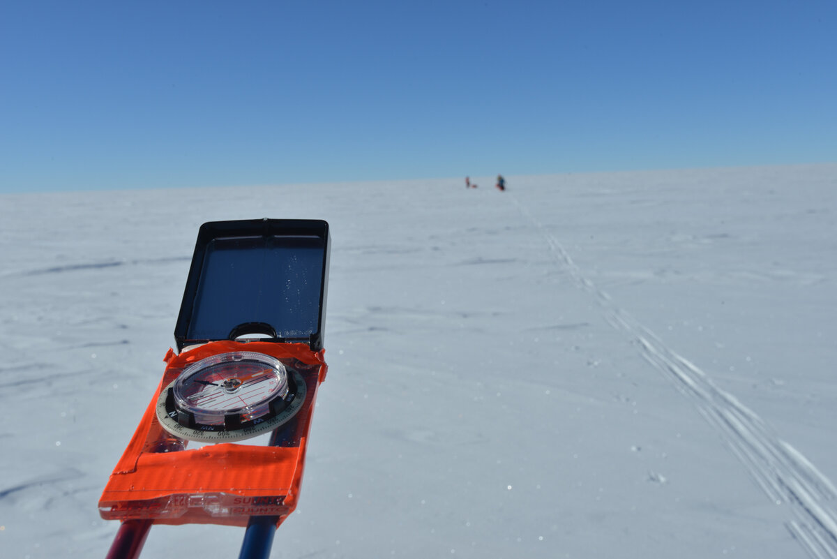 ALE guide checks his bearing, using a chest-mounted compass